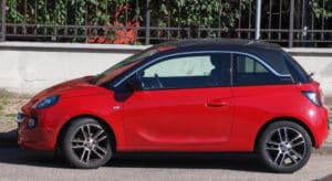 Ein roter Opel Adam, der an einer Straße geparkt ist.