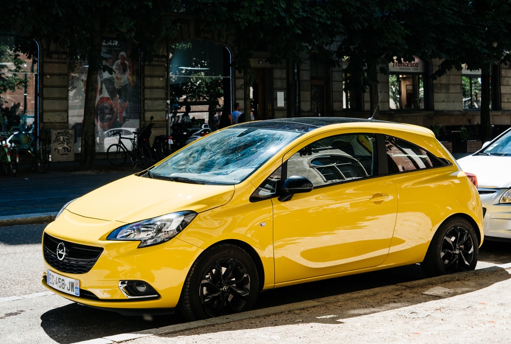 Gelber Opel Corsa, der geparkt an einer Straße steht.