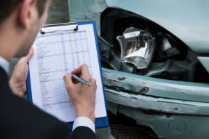 Ein Angestellter der Versicherung erstellt ein Unfallgutachten.